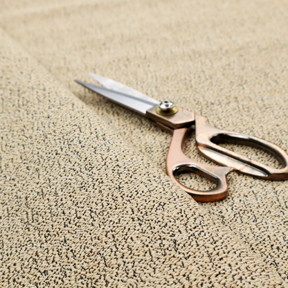 A beige textured fabric with a dense, irregular black speckled pattern.