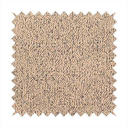 A tan textured fabric with a dense, irregular black speckled pattern.