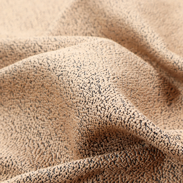 A tan textured fabric with a dense, irregular black speckled pattern.