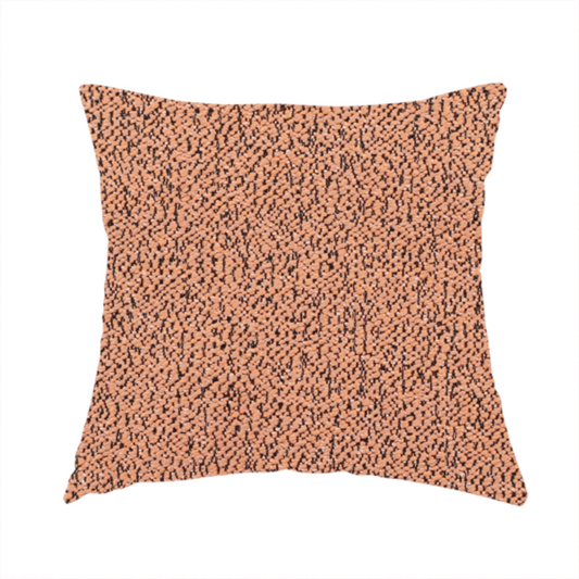 The fabric used to create these handmade cushions is a terracotta orange textured fabric with a dense, irregular black speckled pattern.