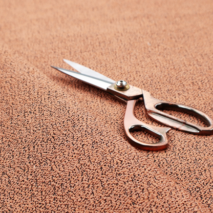 A terracotta orange textured fabric with a dense, irregular black speckled pattern.
