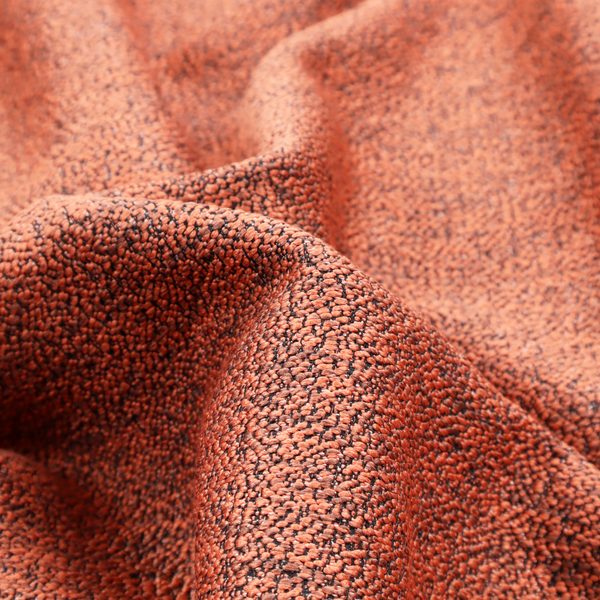 A coral textured fabric with a dense, irregular black speckled pattern.