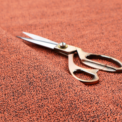 A coral textured fabric with a dense, irregular black speckled pattern.