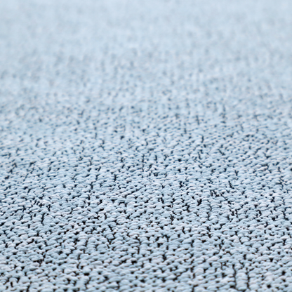 A light blue textured fabric with a dense, irregular black speckled pattern.