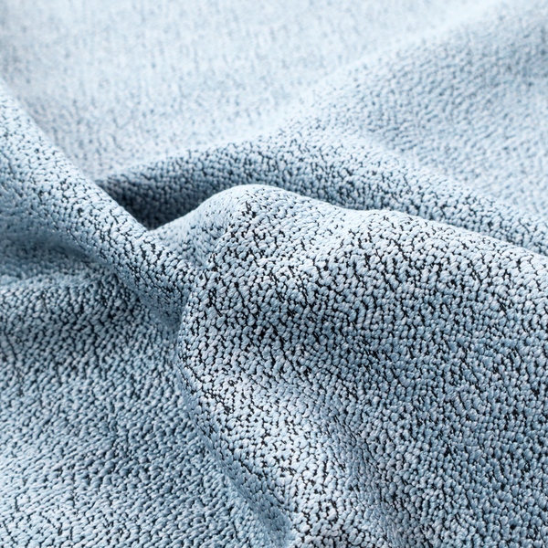 A light blue textured fabric with a dense, irregular black speckled pattern.