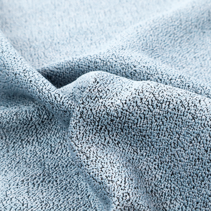 A light blue textured fabric with a dense, irregular black speckled pattern.