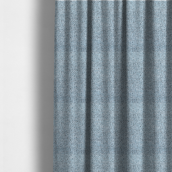 The fabric used to create these made-to-measure curtains is a light blue textured fabric with a dense, irregular black speckled pattern.