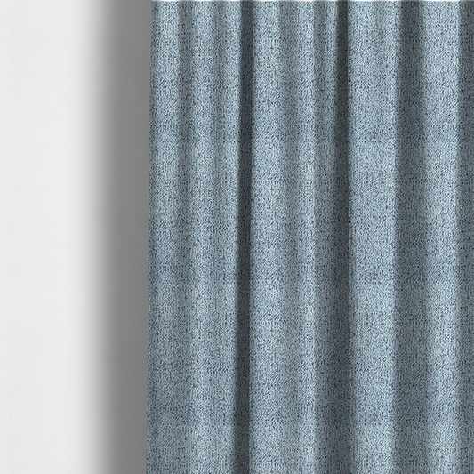 The fabric used to create these made-to-measure curtains is a light blue textured fabric with a dense, irregular black speckled pattern.