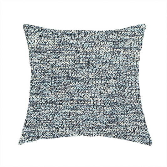 The fabric used to create these handmade cushions is a medium blue textured fabric with a dense, irregular black speckled pattern.