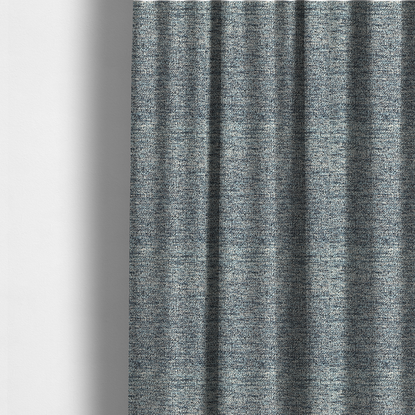 The fabric used to create these made-to-measure curtains is a medium blue textured fabric with a dense, irregular black speckled pattern.