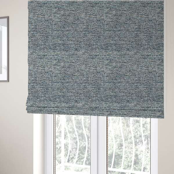 The fabric used to create these Roman blinds is a medium blue textured fabric with a dense, irregular black speckled pattern.