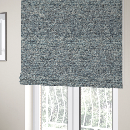 The fabric used to create these Roman blinds is a medium blue textured fabric with a dense, irregular black speckled pattern.