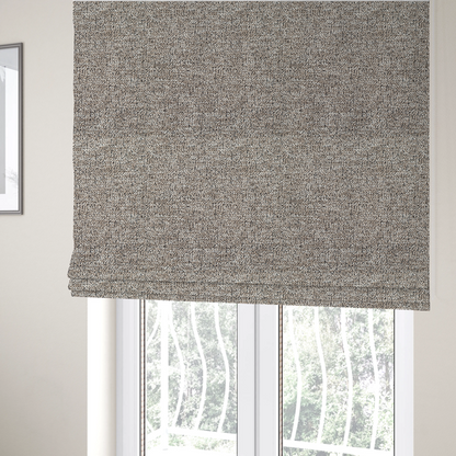 The fabric used to create these Roman blinds is a ash brown textured fabric with a dense, irregular black speckled pattern.
