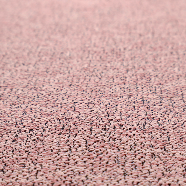 A dusty rose textured fabric with a dense, irregular black speckled pattern.