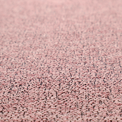 A dusty rose textured fabric with a dense, irregular black speckled pattern.