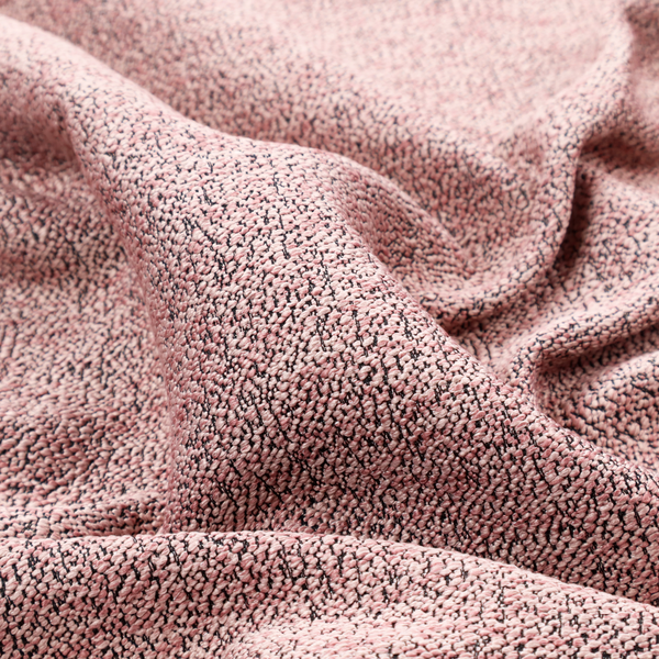 A dusty rose textured fabric with a dense, irregular black speckled pattern.