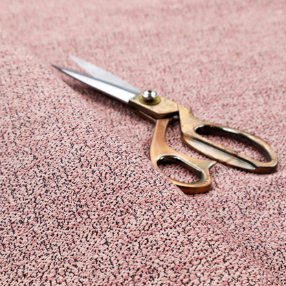A dusty rose textured fabric with a dense, irregular black speckled pattern.