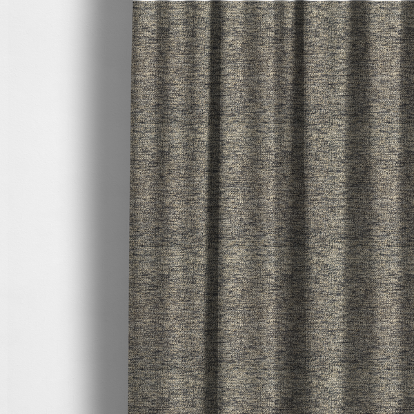 The fabric used to create these made-to-measure curtains is a fossil grey and cream textured fabric with a dense, irregular speckled pattern.