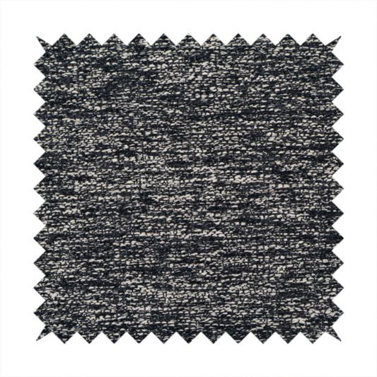 A black textured fabric with a dense, irregular cream and grey speckled pattern.