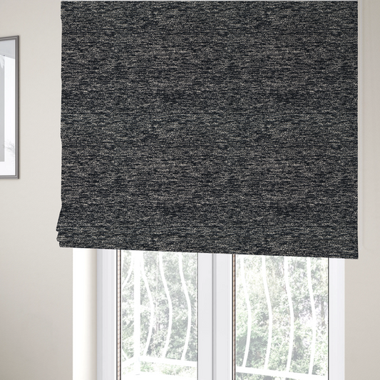 The fabric used to create these Roman blinds is a black textured fabric with a dense, irregular cream and grey speckled pattern.