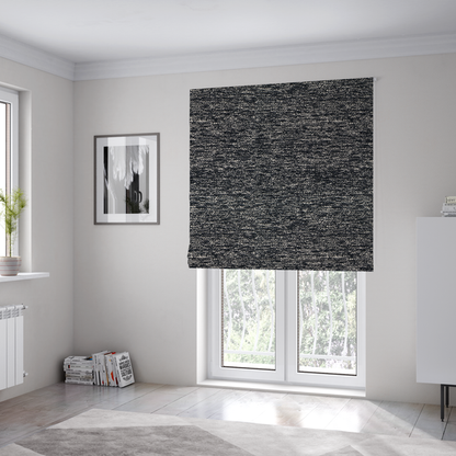 The fabric used to create these Roman blinds is a black textured fabric with a dense, irregular cream and grey speckled pattern.
