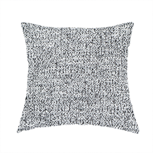 The fabric used to create this handmade cushion is a light grey or silver textured fabric with an integrated black speckled motif, creating a cool-toned, high-contrast pebbled appearance.