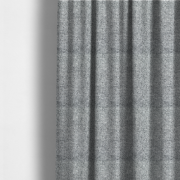 The fabric used to create these made-to-measure curtains is a light grey or silver textured fabric with an integrated black speckled motif, creating a cool-toned, high-contrast pebbled appearance.