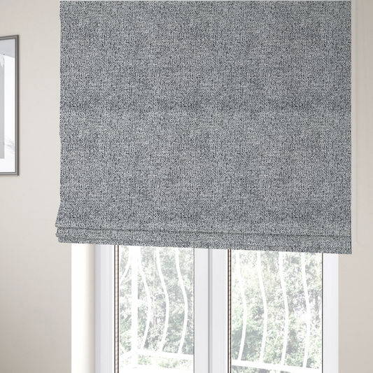 The fabric used to create these Roman blinds is a light grey or silver textured fabric with an integrated black speckled motif, creating a cool-toned, high-contrast pebbled appearance.