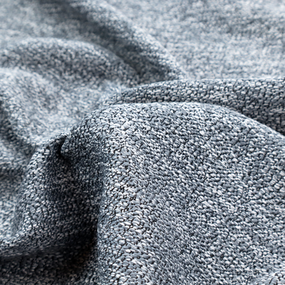 A silver-grey textured fabric with a dense, irregular black speckled pattern.