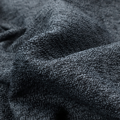 A charcoal grey textured fabric with a dense black speckled pattern, creating a dark, moody salt-and-pepper effect with a heavy pebbled weave.