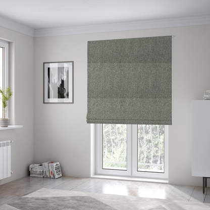 The fabric used to create these Roman blinds is a textured woven upholstery fabric. The material features a dense, multi-tonal weave of sage green, grey, and beige threads, creating a speckled effect with a tactile, matte finish.