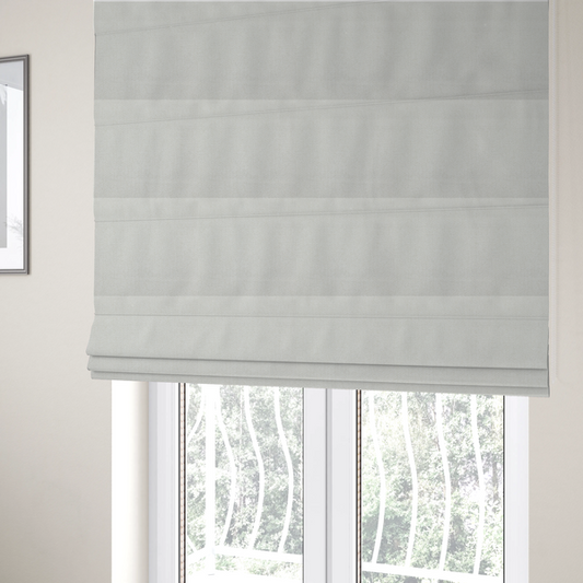 The fabric used to create these Roman blinds is a Chamonix Water Repellent upholstery fabric in White. The material features a dense, textured basket weave with a clean, matte finish and high-durability construction.