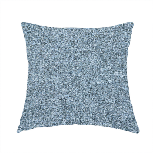 Fabric used to create this handmade cushion is a Chamonix Water Repellent upholstery fabric in Denim Blue. The material features a dense, multi-tonal basket weave texture with blue and grey threads and a durable, matte finish.