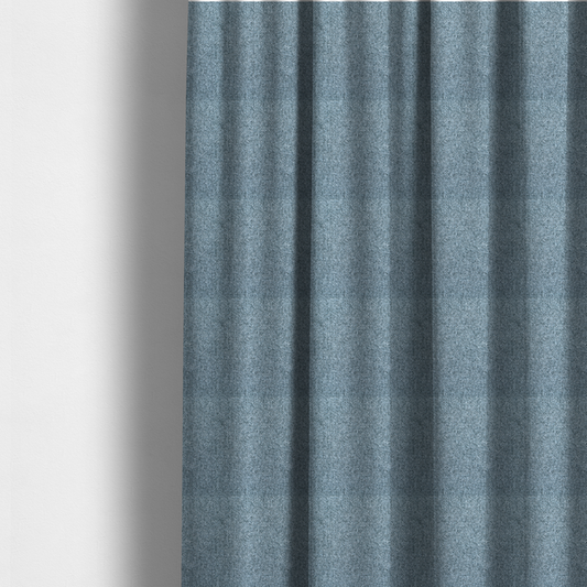 The fabric used to create these made-to-measure curtains is a Chamonix Water Repellent upholstery fabric in Denim Blue. The material features a dense, multi-tonal basket weave texture with blue and grey threads and a durable, matte finish.