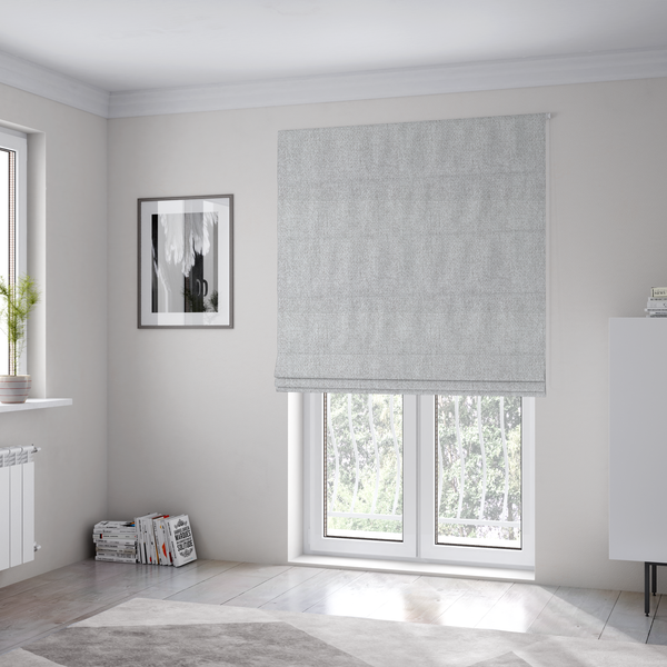 The fabric used to create these Roman blinds is a Chamonix Water Repellent upholstery fabric in Silver. A clean, light-grey basket weave texture with a subtle effect and a sophisticated matte finish.