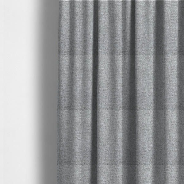 The fabric used to create these made-to-measure curtains is a weathered fabric blends charcoal and slate yarns with cool silver and off-white threads, resulting in a balanced, stony neutral that offers a modern and professional aesthetic.