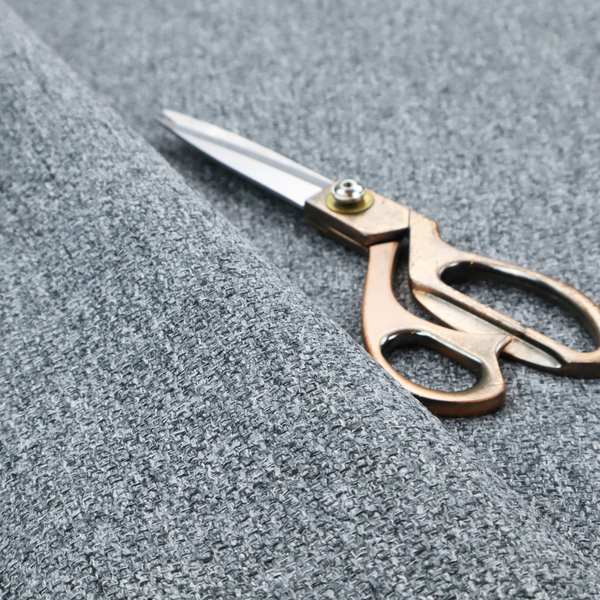 A cool, industrial Steel Grey. This fabric features a high-contrast effect, interlacing charcoal, silver, and bright white threads to create a crisp, textured look that mimics the appearance of salt-and-pepper granite.