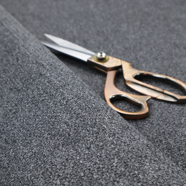 A deep, dramatic Charcoal Grey. This fabric features a high-density basket weave that blends dark soot tones with flecks of slate and silver. The tight, pebbled texture gives the dark colour a sophisticated, matte architectural feel.