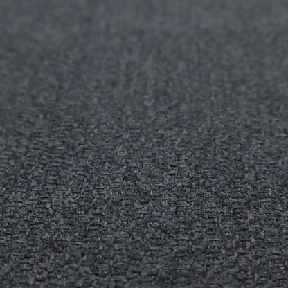 A deep, obsidian Black. Unlike a flat solid, this fabric uses a dense basket weave to create a rich, textured surface. The interlacing yarns catch the light in a way that provides a soft charcoal sheen, adding depth to the dark palette.