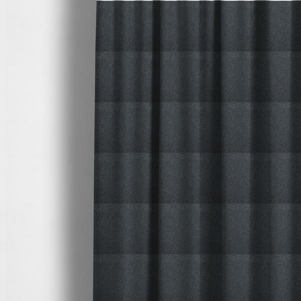 The fabric used to create these made-to-measure curtains is a deep, obsidian Black. Unlike a flat solid, this fabric uses a dense basket weave to create a rich, textured surface. The interlacing yarns catch the light in a way that provides a soft charcoal sheen, adding depth to the dark palette.