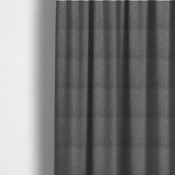 The fabric used to create these made-to-measure curtains is a  graphite grey woven fabric with a dense, multi-tonal heathered texture.