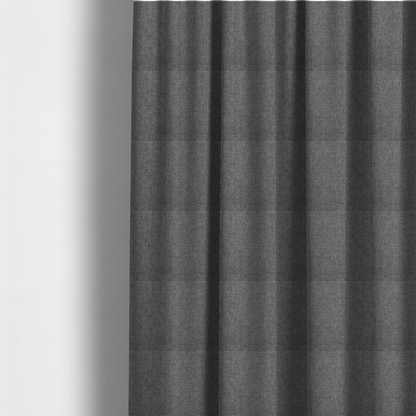 The fabric used to create these made-to-measure curtains is a  graphite grey woven fabric with a dense, multi-tonal heathered texture.