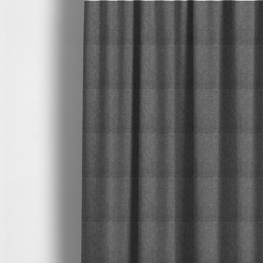 The fabric used to create these made-to-measure curtains is a  graphite grey woven fabric with a dense, multi-tonal heathered texture.
