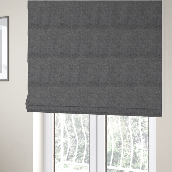 The fabric used to create these Roman blinds is a graphite grey woven fabric with a dense, multi-tonal heathered texture.
