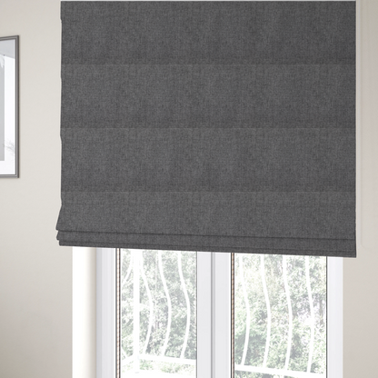 The fabric used to create these Roman blinds is a graphite grey woven fabric with a dense, multi-tonal heathered texture.