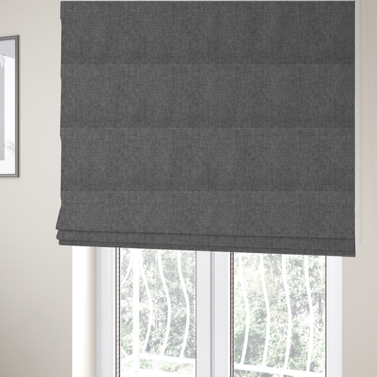 The fabric used to create these Roman blinds is a graphite grey woven fabric with a dense, multi-tonal heathered texture.