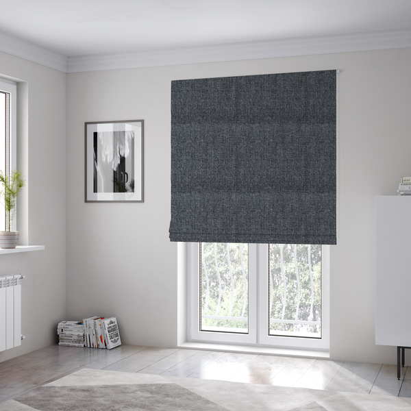 The fabric used to create these Roman blinds is a dark charcoal grey woven fabric with a heavy, multi-tonal heathered texture.