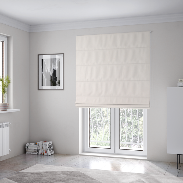 The fabric used to create these Roman blinds features a dense, soft pile with a subtle matte sheen. The warm, off-white cream tone is uniform throughout, offering a luxurious and durable finish suitable for high-end upholstery.