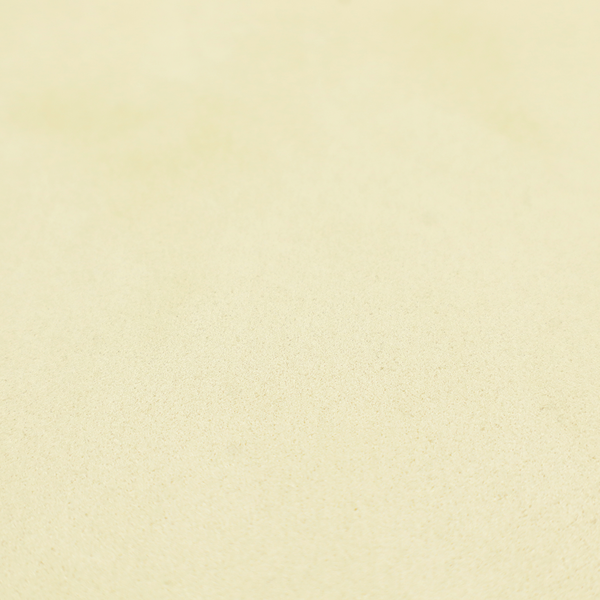 Annecy Water Repellent Velvet in Ivory. The fabric displays a dense, plush pile with a soft matte finish in a warm, buttery off-white shade. Its uniform texture and specialized water-resistant coating make it a luxurious yet practical choice for upholstery.