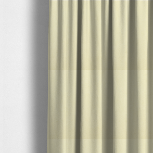 The fabric used to create these made-to-measure curtains displays a dense, plush pile with a soft matte finish in a warm, buttery off-white shade. Its uniform texture and specialized water-resistant coating make it a luxurious yet practical choice for upholstery.